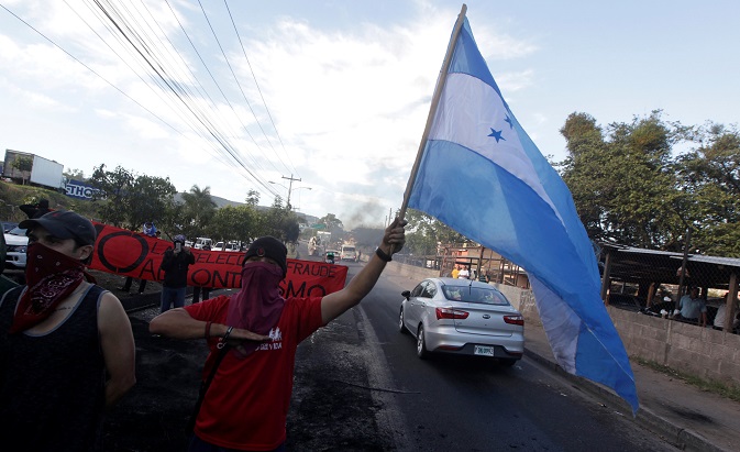 Opposition supporters sing Honduras' national anthem at a barricade during a protest after the U.S. backed the re-election of Honduran President Juan Orlando Hernandez, in Tegucigalpa, Honduras December 27, 2017.