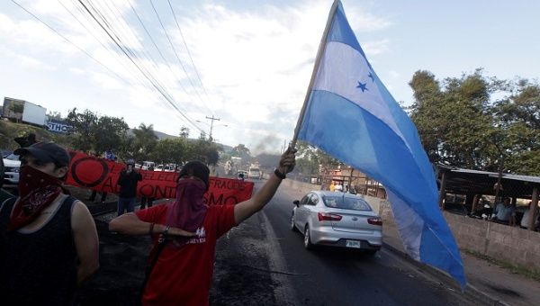 Opposition supporters sing Honduras' national anthem at a barricade during a protest after the U.S. backed the re-election of Honduran President Juan Orlando Hernandez, in Tegucigalpa, Honduras December 27, 2017.