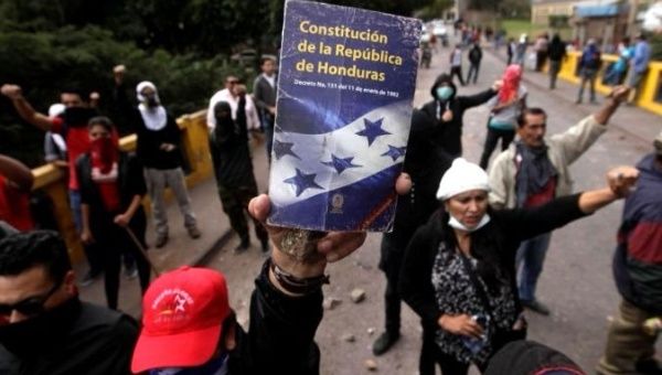 An opposition supporter holds up the Constitution of the Republic of Honduras during a protest over a contested presidential election with allegations of electoral fraud in Honduras.