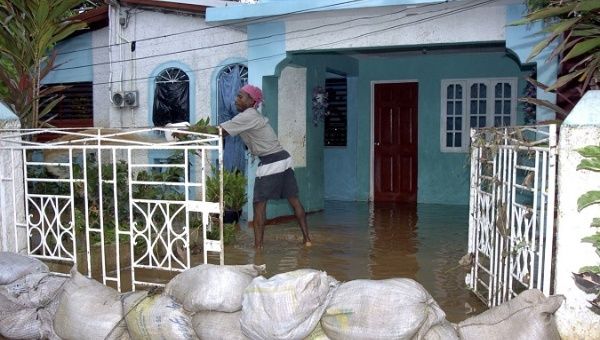  A man drains water from his house flooded after the passage of Hurricane Dennis in the city of Kigston, Jamaica