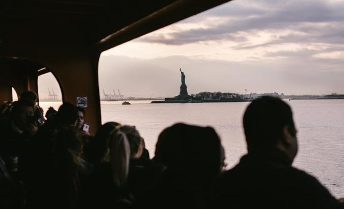 The Statue of Liberty can be seen through the windows of the Staten Island Ferry in New York, New York.