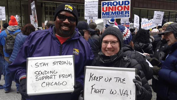 Demonstrators at Chicago's Rally for Workers' Rights holding signs in support of the West Virginia teachers strike. Feb. 24, 2018.