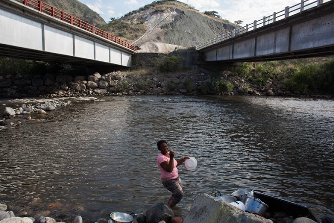A woman washes her clothes in the Chota River just below the Panamerican highway. Poverty and lack of government investment make the Valley one of the poorest areas of Ecuador. 