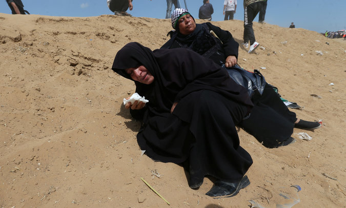 Female Palestinian demonstrators react to tear gas fired by Israeli troops