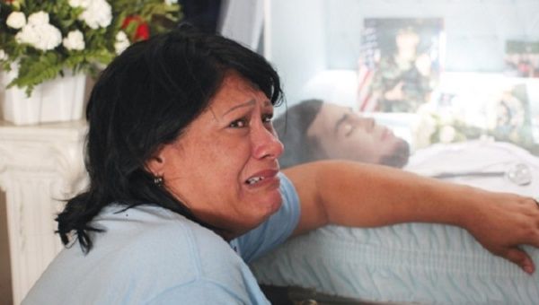 Lucyvette Padro mourns next to the body of her son, Angel Candelario Padro, during his wake in his hometown of Guanica, Puerto Rico.