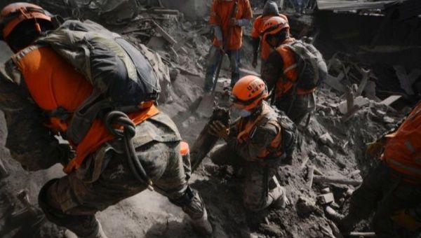 Soldiers search for remains at an area affected by the eruption of El Fuego volcano in Guatemala.