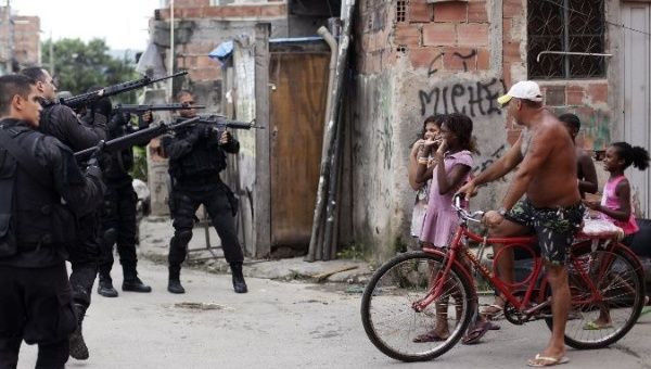 Policemen brandish their weapons in Complexo da Mare favelas in Rio de Janeiro, Brazil.