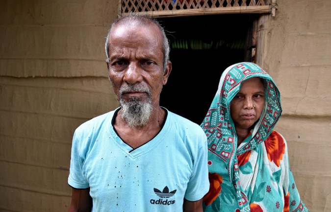 Abdul Suban and his wife pose for a photograph outside their home in Nellie village, in Morigaon district, in the northeastern state of Assam, India July 25, 2018.