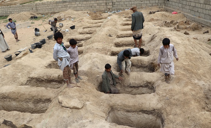 Boys inspect graves prepared for victims of Thursday's air strike in Saada province, Yemen.