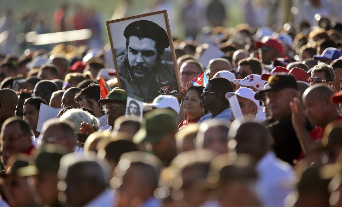People in Cuba carry a portrait of Che during an act to commemorate the 50th anniversary of his death.