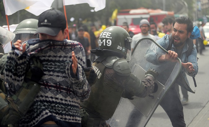 A demonstrator clashes with a riot policeman during a rally against Chilean pension fund administrators, in Santiago, Chile, Oct. 24, 2018.