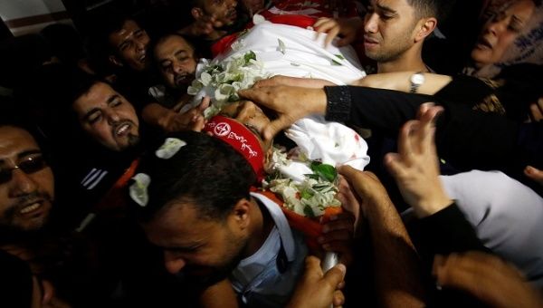 Palestinian mourners carry the body of Mohammed Odah, killed by an Israeli air strike in the northern Gaza Strip.