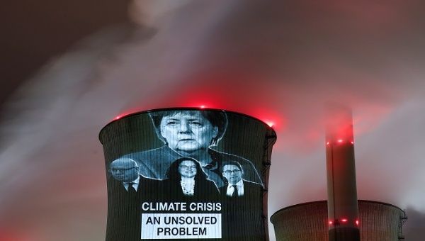 Greenpeace activists project images of German politicians onto a cooling tower in Cologne, Germany, Dec. 14, 2018.