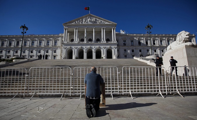 A protester kneels in front of the Portuguese parliament, Lisbon, Portugal, 26 Nov. 2013.