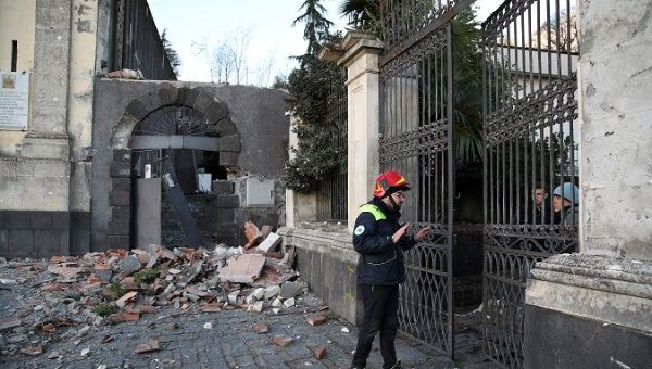 A rescue man speaks to residents of a building damaged by an earthquake, measuring magnitude 4.8, at the area north of Catania on the slopes of Mount Etna in Sicily, Italy, December 26, 2018.