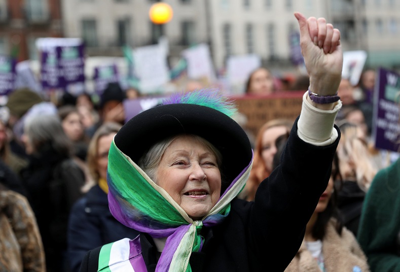 A woman dressed as suffragette gestures during the Women's March calling for equality, justice and an end to austerity in London, Britain.
