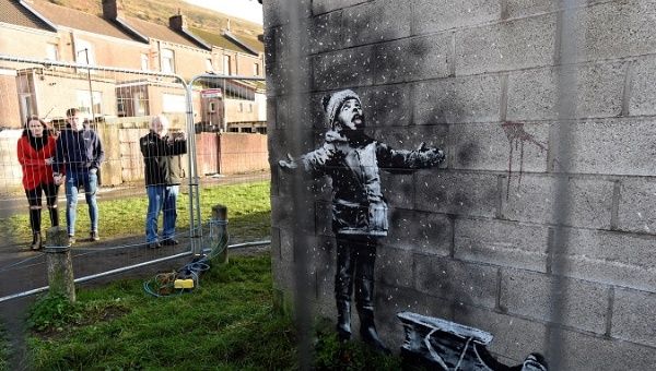 People view new work by the artist Banksy that appeared during the week on the walls of a garage in Port Talbot, Britain December 22, 2018. REUTERS/Rebecca Naden/File Photo