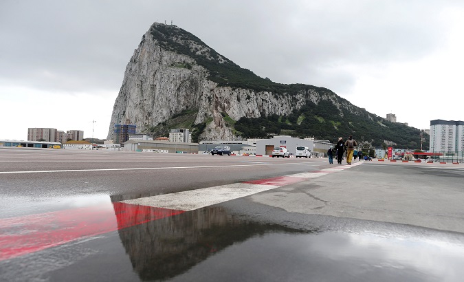 Pedestrians cross the tarmac at Gibraltar International Airport, near the border with Spain in the British overseas territory of Gibraltar, historically claimed by Spain.