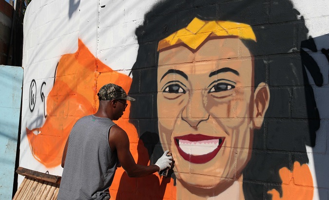 A man paints Marielle Franco's face and demands punishment of the guilty in Rio de Janeiro, Brazil, Mar. 18, 2018.