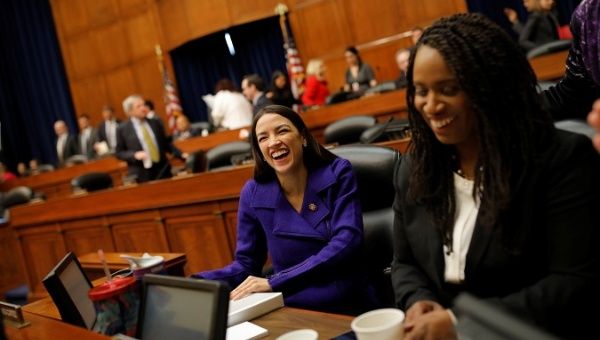 U.S. Reps Alexandria Ocasio-Cortez and Ayanna Pressley smile during a House Oversight and Reform Committee meeting in Washington, U.S.