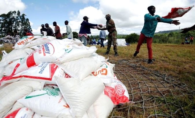 A group of people stack maize donated after Cyclone Idai ravished Zimbabawe.