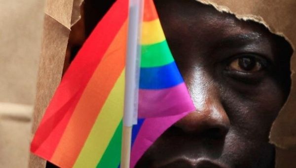 An asylum seeker from Uganda poses as he marches with the LGBT Asylum Support Task Force during the Gay Pride Parade in Boston, Massachusetts June 8, 2013.