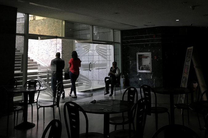 People walk out of a mall during a partial power cut in Caracas, Venezuela August 20, 2019.