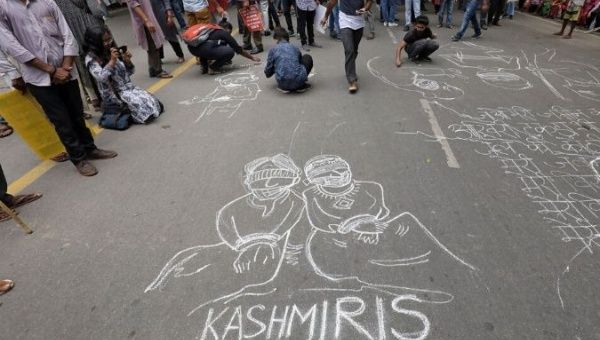 People draw and write messages on a road during a protest against the scrapping of the special constitutional status for Kashmir by the government, in New Delhi, India, August 7, 2019. 