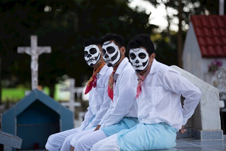 Teens gather at the municipal cemetery to celebrate the Hanal Pixan in Lerona Vicario town, Quintana Roo, Mexico, Oct. 31, 2019.