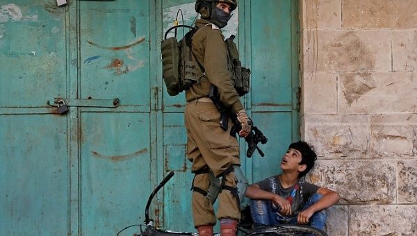 Israeli soldier detains a Palestinian boy in the Israeli-occupied West Bank, Nov. 29, 2019.
