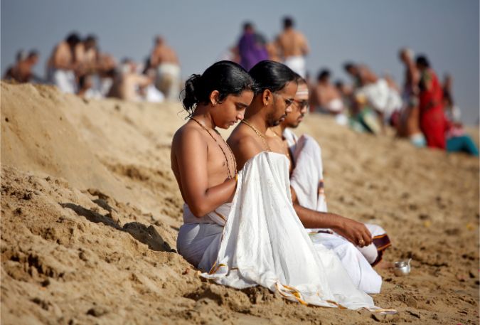 People pray during a prayer ceremony for the victims of the 2004 tsunami on the 15th anniversary of the disaster, at Marina beach in Chennai, India, December 26, 2019.
