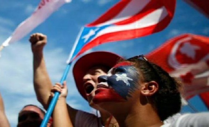 Woman holds a Puerto Rican flag during a protest against corruption, 2019.