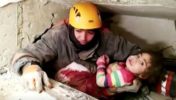 A rescue worker holds a child that was found alive in the rubble of a collapsed building in Elazig, Turkey, Jan. 25, 2020 in this still image taken from video. 