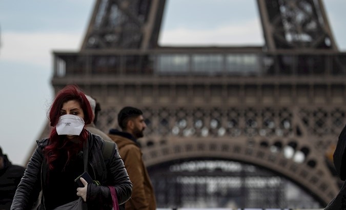 A woman wears a protective face mask near the Eiffel Tower, Paris, France, Feb. 15, 2020.