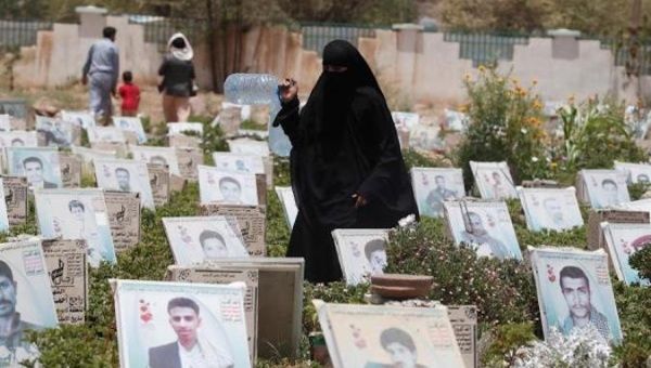 A woman walks among the graves of people killed in Yemen's prolonged fighting, at a cemetery in Sana'a, 23 June 2020. 