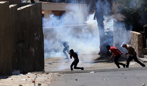Palestinian protesters run to seek cover from tear gas fired by Israeli soldiers, West Bank city of Nablus, 03 July 2020.