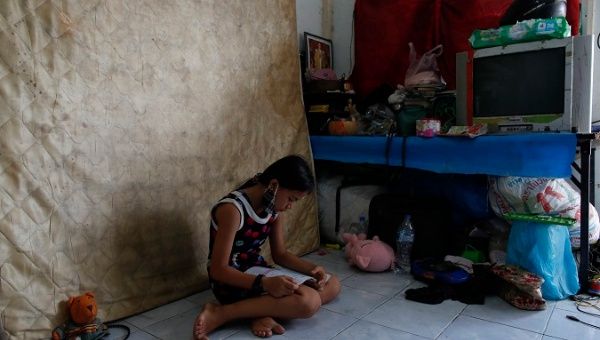 Tanaporn Rachiwong, a 10-year-old Thai girl from a low income family, reads to practice education lessons as she has no internet access for new online learning classes at a house in Klong Toey slum community in Bangkok, Thailand, 18 May 2020.