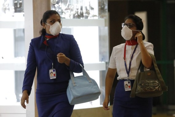 Staff members wear protective masks in the boarding area of international flights at the Jorge Chavez International Airport, in the constitutional province of Callao, Peru, on March 6, 2020.