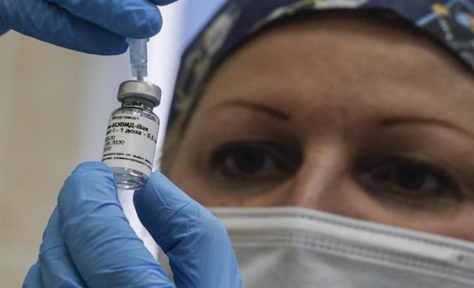 A Russian medical worker prepares a trial vaccine for a volunteer, Moscow, Russia, Sept. 17, 2020.