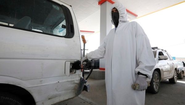 An attendant wearing personal protective equipment pumps fuel into a vehicle at a petrol station amid an acute shortage of fuel supplies in Sana'a, Yemen.