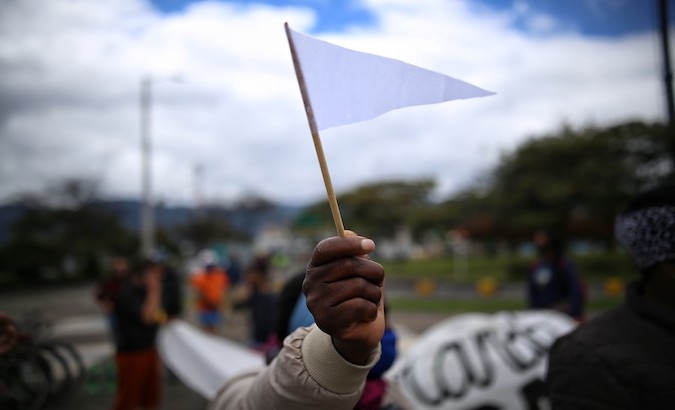 A person holds a white flag, symbol of peace, during a protest in Antioquia, Colombia, Jan 14, 2021.