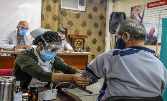 A Health worker checks the blood pressure of a volunteer before giving him a dose of Soberana 02, Havana, Cuba, Jan. 19, 2021.