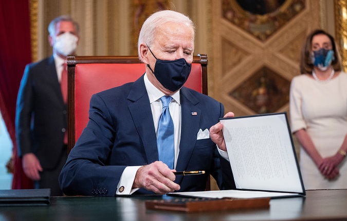 U.S. President Joe Biden signs documents on the Capitol this January 20, 2021.