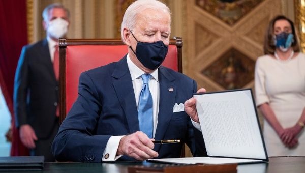 U.S. President Joe Biden signs documents on the Capitol this January 20, 2021.