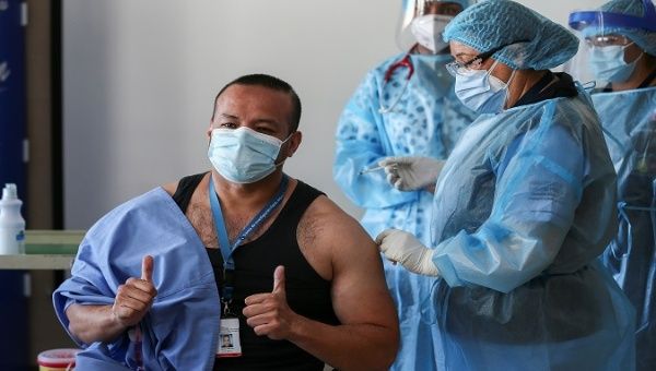 A man receives a COVID-19 vaccine dose, Ecuador, 2021.