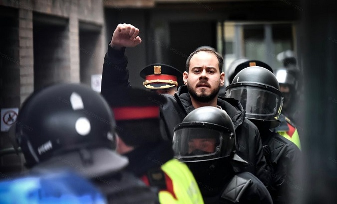 Pedro Hasel raises his arm while being arrested, Lleida, Spain, Feb. 16, 2021.