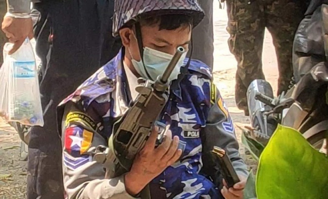 Police officer loads an Uzi gun during protests in Myanmar, March 3, 2021.