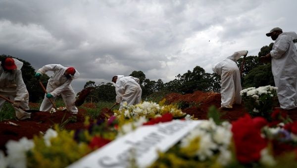 Workers bury corpses of people who succumbed to COVID-19, Sao Paulo, Brazil, March 8, 2021.
