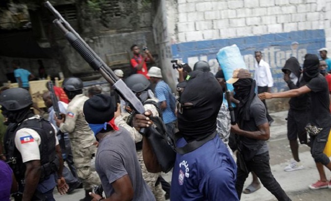 Hooded police officers head toward a police station in Port-au-Prince, Haiti, March 17, 2021.
