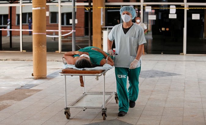 A health worker transfers a COVID-19 patient on a stretcher, Asuncion, Paraguay, March 10, 2021.